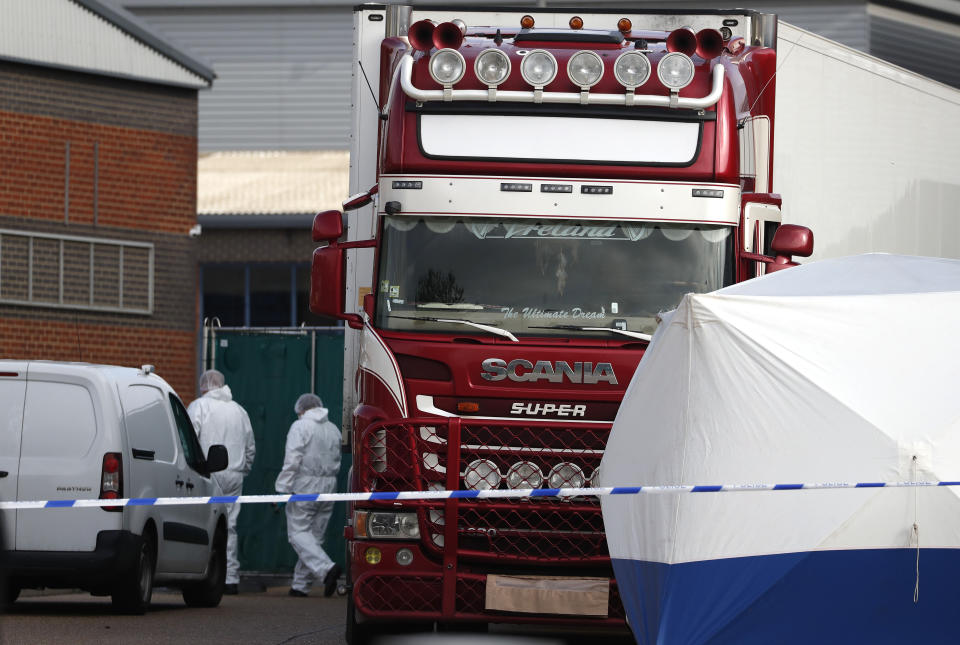 Police forensic officers attend the scene after a truck was found to contain a large number of dead bodies, in Thurrock, South England, early Wednesday Oct. 23, 2019. Police in southeastern England said that 39 people were found dead Wednesday inside a truck container believed to have come from Bulgaria. (AP Photo/Alastair Grant)