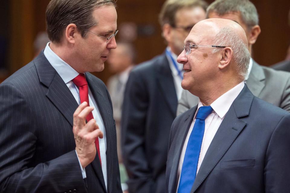 Sweden's Finance Minister Anders Borg, left, talks with France's Finance Minister Michel Sapin during a meeting of EU finance ministers at the European Council building in Brussels, Tuesday May 6, 2014. (AP Photo/Geert Vanden Wijngaert)