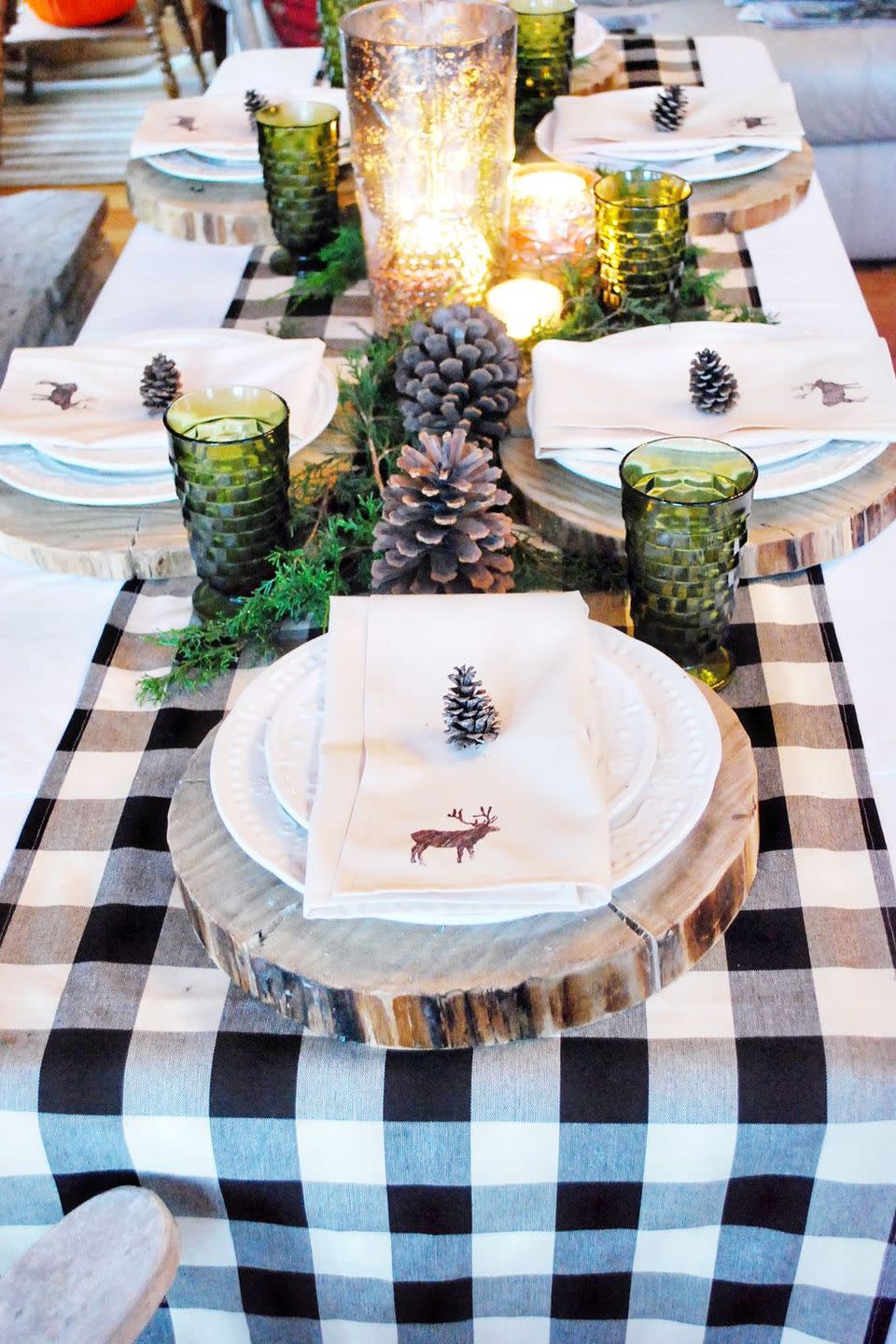 <p>Fresh greenery, large pine cones, and green-tinted glass make for a stunning, woods-inspired scene. A gingham runner and hand-painted napkins keep things whimsical and fun.</p><p><strong>Get the tutorial at <a href="http://thewhitebuffalostylingco.com/life-of-splendor-christmas-line/" rel="nofollow noopener" target="_blank" data-ylk="slk:The White Buffalo Styling Co;elm:context_link;itc:0;sec:content-canvas" class="link ">The White Buffalo Styling Co</a>.</strong> </p><p><strong><a class="link " href="https://www.amazon.com/SoarDream-Thanksgiving-Christmas-Gathering-Decorations/dp/B07X2XJNJB/ref=sr_1_4_sspa?crid=OCO1J4MAWDGQ&keywords=black%2Bgingham%2Brunner&qid=1669154369&sprefix=black%2Bgingham%2Brunner%2Caps%2C217&sr=8-4-spons&sp_csd=d2lkZ2V0TmFtZT1zcF9hdGY&th=1&tag=syn-yahoo-20&ascsubtag=%5Bartid%7C10050.g.644%5Bsrc%7Cyahoo-us" rel="nofollow noopener" target="_blank" data-ylk="slk:Shop Now;elm:context_link;itc:0;sec:content-canvas">Shop Now</a><br></strong></p>