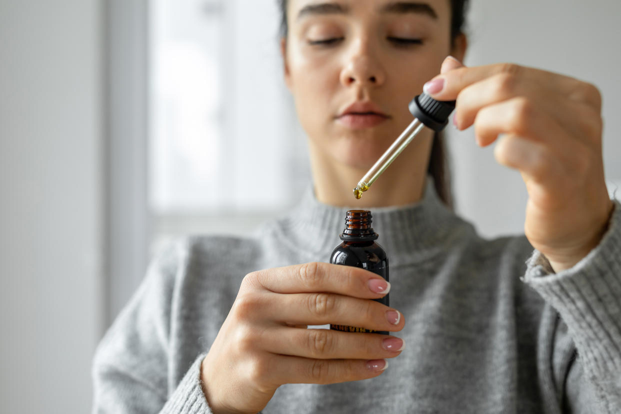 Woman holding CBD oil drops