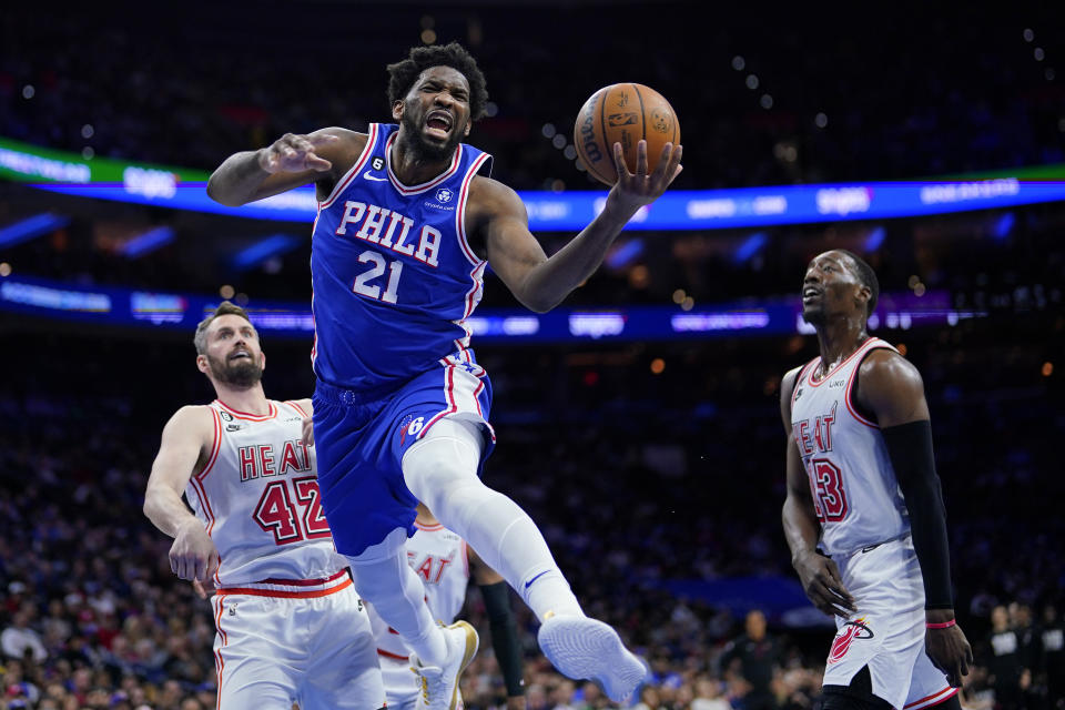 Philadelphia 76ers' Joel Embiid (21) goes up for a shot past Miami Heat's Kevin Love (42) during the first half of an NBA basketball game, Monday, Feb. 27, 2023, in Philadelphia. (AP Photo/Matt Slocum)