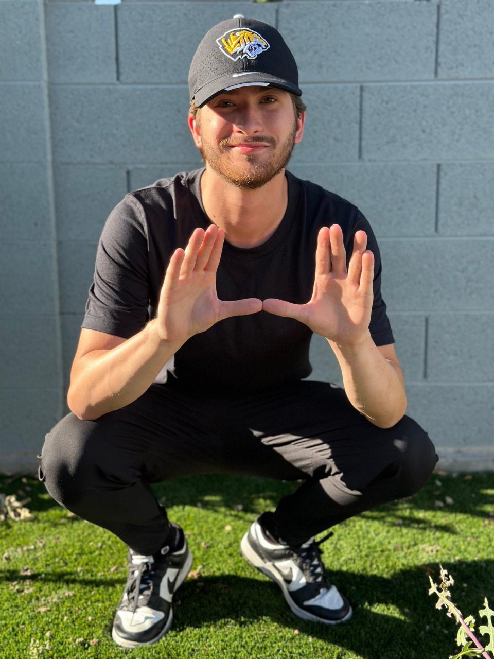 Cole Topham poses a photo after announcing his hire as an offensive analyst and creative director at Saguaro High School.