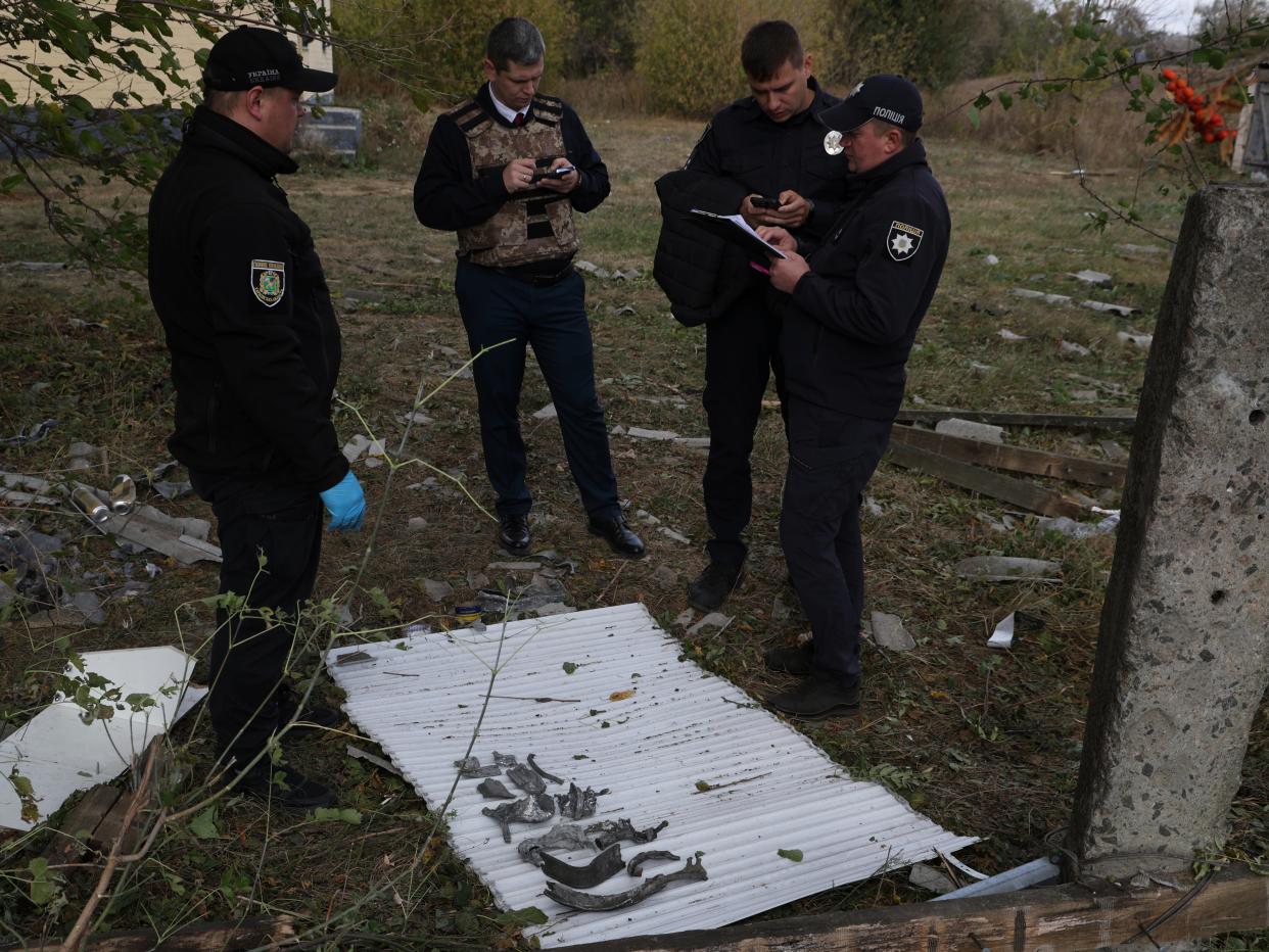 Police officers inspect the fragments of a Russian missile (AP)