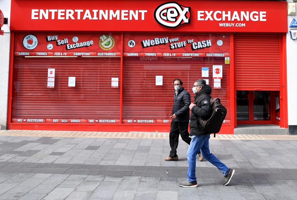 Pedestrians wearing PPE (personal protective equipment), of a face mask or covering as a precautionary measure against spreading COVID-19, walk past shuttered shops in the city centre of Leicester, central England, on June 30, 2020. - Britain on Monday reimposed lockdown measures on a city hit by an outbreak of coronavirus, in the first big test of Prime Minister Boris Johnson's "whack-a-mole" strategy to control the disease while getting the economy moving again. (Photo by JUSTIN TALLIS / AFP) (Photo by JUSTIN TALLIS/AFP via Getty Images)