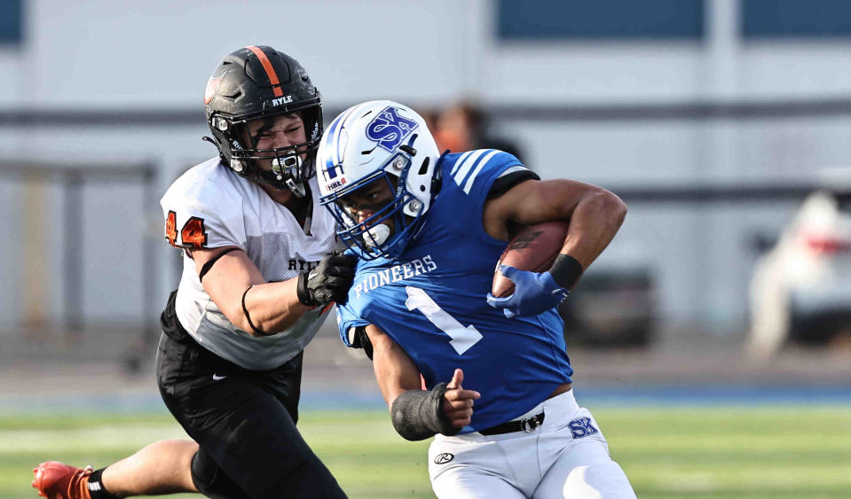 Simon Kenton running back Jayden Lawson is pulled down by Ryle's Dillion Smith during their game Saturday.