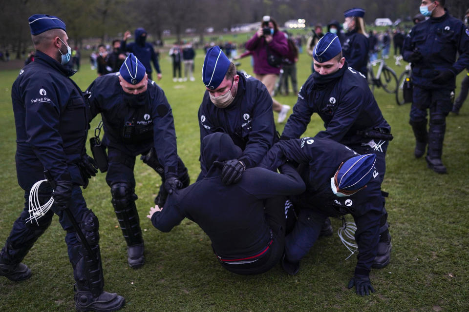 FILE - In this Friday, April 2, 2021 file photo police detain a man in the Bois de la Cambre park in Brussels. Brussels prosecutors warned potential party-goers they should stay away from an illegal gathering planned this weekend in one of the city's biggest park as police briefly detained one of the organizers on Tuesday, April 27, 2021. (AP Photo/Francisco Seco, File)