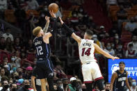 Orlando Magic guard Hassani Gravett (12) shoots as Miami Heat guard Tyler Herro (14) defends during the first half of an NBA basketball game, Sunday, Dec. 26, 2021, in Miami. (AP Photo/Lynne Sladky)