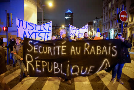 Several thousand police officers and firemen attend an unauthorised protest against anti-violence late in the night in Lyon, France, October 26, 2016. The banners read " Lax Justice" and "Cheap security". REUTERS/Robert Pratta