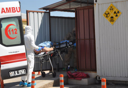 A Syrian man from Idlib is carried by Turkish medics wearing chemical protective suits to a hospital in the border town of Reyhanli in Hatay province, Turkey, April 4, 2017. Ferhat Dervisoglu/Dogan News Agency via REUTERS