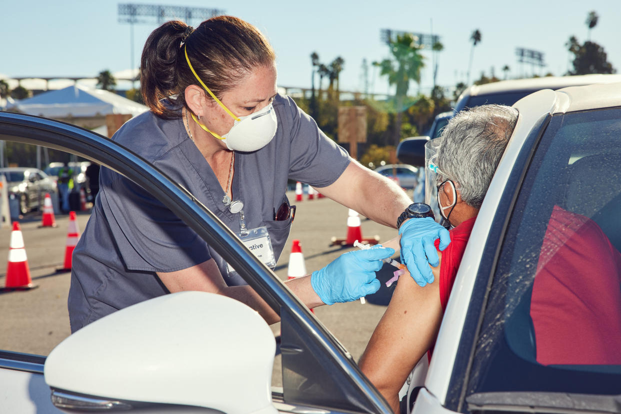 Stacey Manson, a nurse, gives a vaccination at Dodger Stadium in Los Angeles, Jan. 20, 2021.  (Ryan Young/The New York Times)