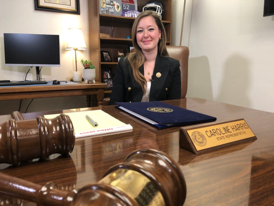 
woman sits behind a desk with gavels on it
        