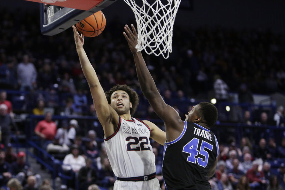 Gonzaga forward Anton Watson (22) shoots while defended by BYU forward Fousseyni Traore (45) during the second half of an NCAA college basketball game Saturday, Feb. 11, 2023, in Spokane, Wash. Gonzaga won 88-81. (AP Photo/Young Kwak)