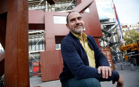 Dutch artist Joep van Lieshout poses for photographs in front of his sculpture "Domestikator", displayed in the plaza outside the Centre Pompidou modern art museum in Paris, Tuesday, Oct. 17, 2017. - Credit: Thibault Camus/AP