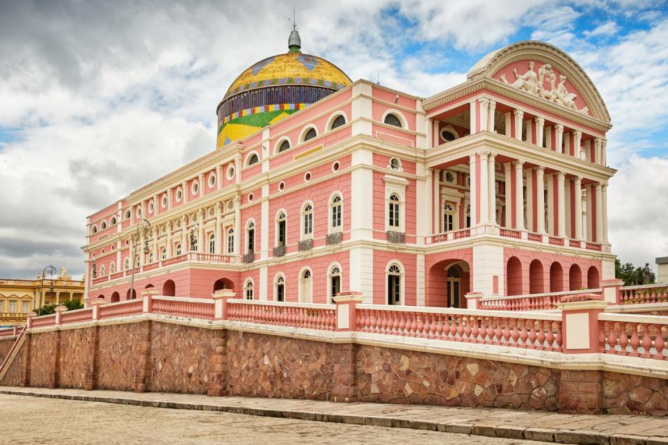 <p>During the height of the 20th-century rubber boom, business elites sought to re-create the lavish lifestyle seen across Europe by building an extravagant opera house in the Amazon. Furniture from Paris, marble and glass from Italy, and nearly 36,00 decorated tiles were called in to create blush beauty in Manaus, but its days as a thriving opera house were numbered. </p><p>Not long after its first performance in 1897, the invention of artificial rubber led to the wealthy leaving the Brazilian city and the opera house they worked so hard to build. Luckily, in 2001, a new populist government of the Amazon region funded a project to restore the theater and bring entertainment back into the area. Today, <a href="https://teatroamazonas.com.br/" rel="nofollow noopener" target="_blank" data-ylk="slk:Teatro Amazonas;elm:context_link;itc:0;sec:content-canvas" class="link ">Teatro Amazonas</a> is home to the Amazon Philharmonic orchestra and hosts an annual film festival.</p>