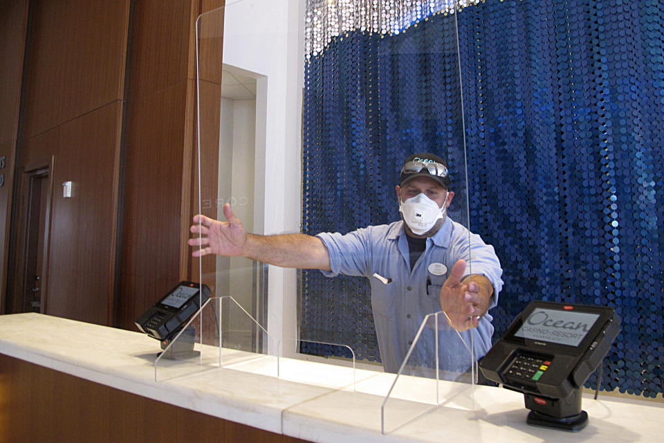 A worker at the Ocean Casino resort in Atlantic City, N.J., installs a protective panel at a check-in area on June 3, 2020, about a month before it reopened during the early days of the COVID19 pandemic. On Jan. 24, 2024, the New Jersey Supreme Court rejected an attempt by the casino to collect on a business interruption policy for the 3 1/2 months it was closed due to the pandemic. (AP Photo/Wayne Parry)