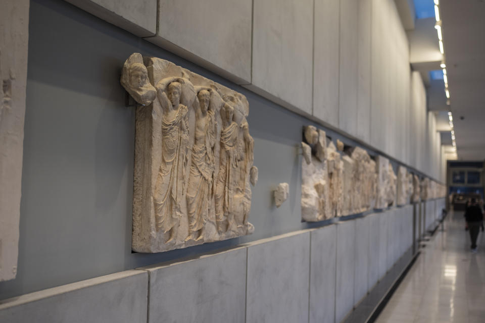 A newly placed male head, left, is seen on a frieze of the Acropolis museum during a ceremony for the repatriation of three sculpture fragments, in Athens, Greece, Friday, March 24, 2023. Greece received three fragments from the ancient Parthenon temple that had been kept at Vatican museums for two centuries. Culture Ministry officials said the act provided a boost for its campaign for the return of the Parthenon Marbles from the British Museum in London. (AP Photo/Petros Giannakouris)