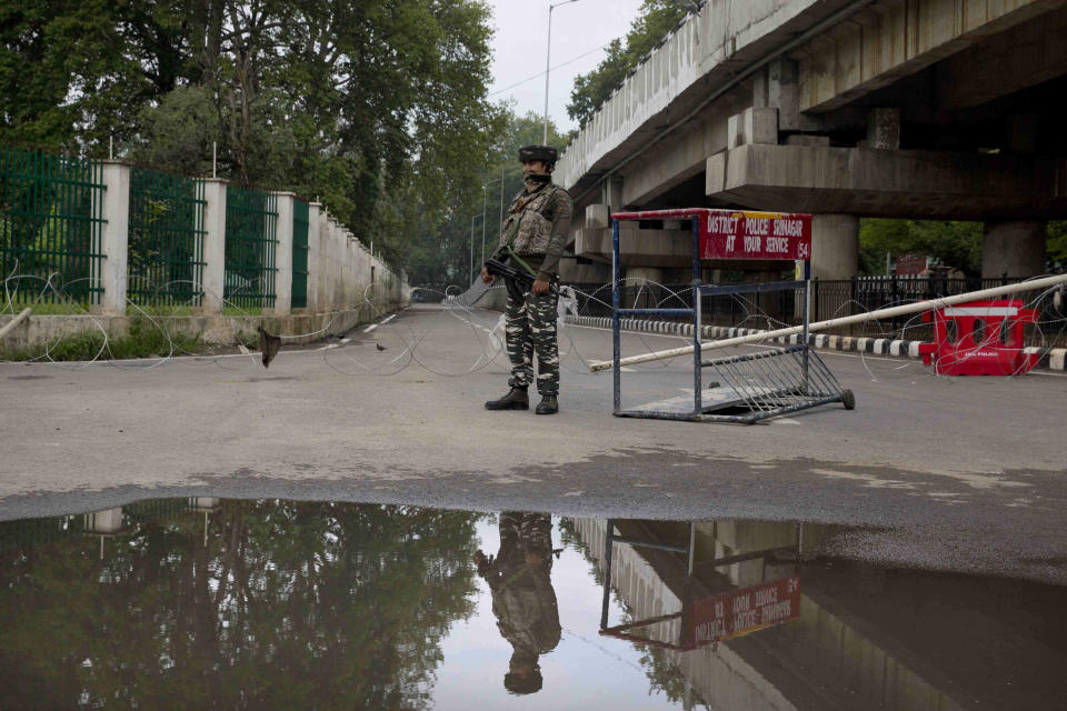 Indian paramilitary soldier stands guard near a temporary checkpoint on the road leading towards Independence Day parade venue during lockdown in Srinagar, Indian controlled Kashmir, Thursday, Aug. 15, 2019. Indian Prime Minister Narendra Modi says that stripping the disputed Kashmir region of its statehood and special constitutional provisions has helped unify the country. Modi gave the annual Independence Day address from the historic Red Fort in New Delhi as an unprecedented security lockdown kept people in Indian-administered Kashmir indoors for an eleventh day. (AP Photo/ Dar Yasin)