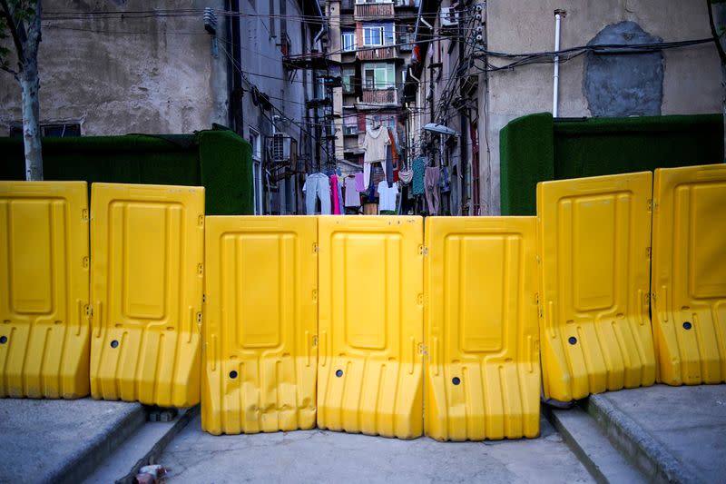 Lines of laundry are seen hanging between apartments behind barricades, which have been built to block buildings from a street, after the lockdown was lifted in Wuhan