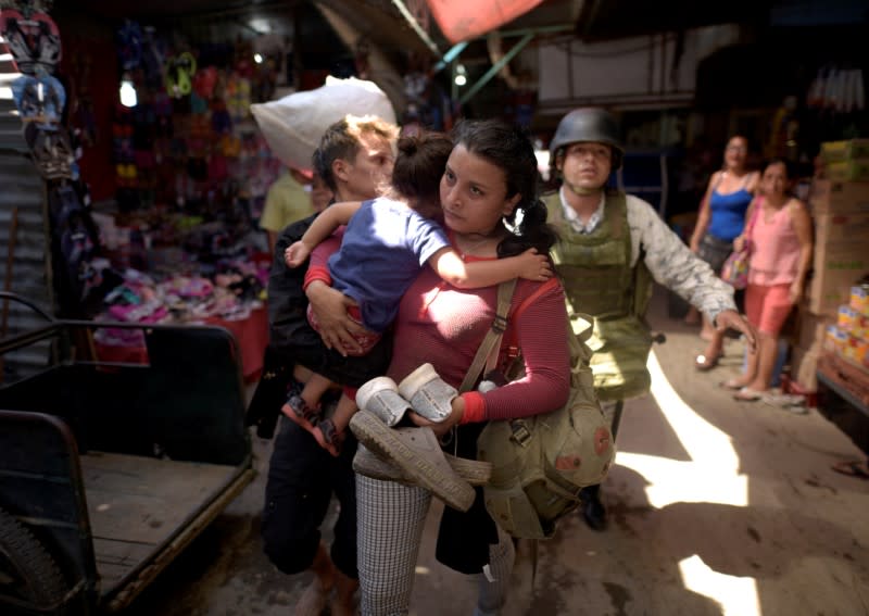 A member of Mexico's National Guard escort migrants, part of a caravan travelling to the U.S., near the border between Guatemala and Mexico, in Ciudad Hidalgo