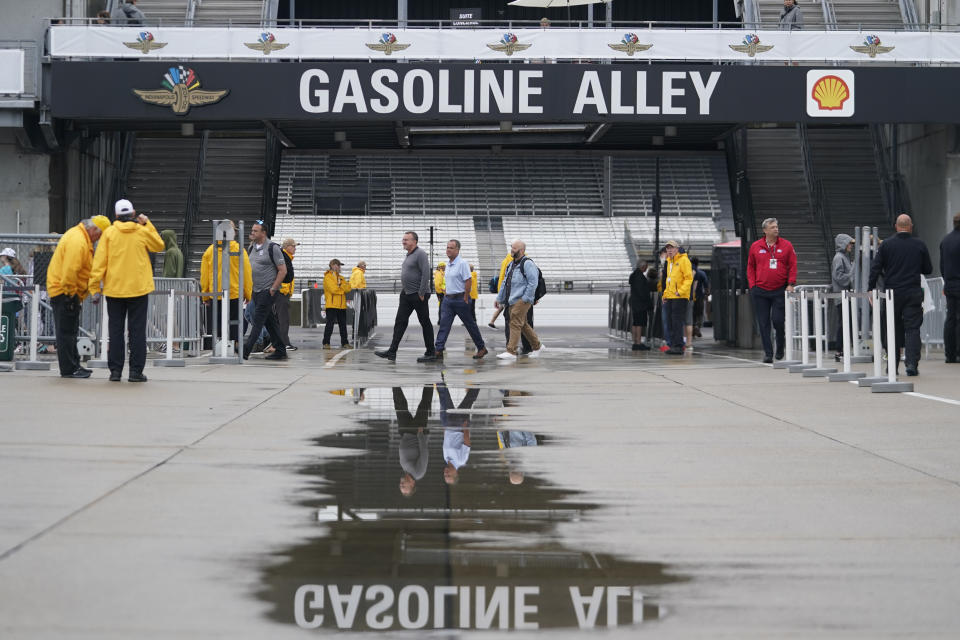 Race fans walk into Gasoline Alley during a rain delay before practice for the Indianapolis 500 auto race at Indianapolis Motor Speedway, Tuesday, May 16, 2023, in Indianapolis. (AP Photo/Darron Cummings)