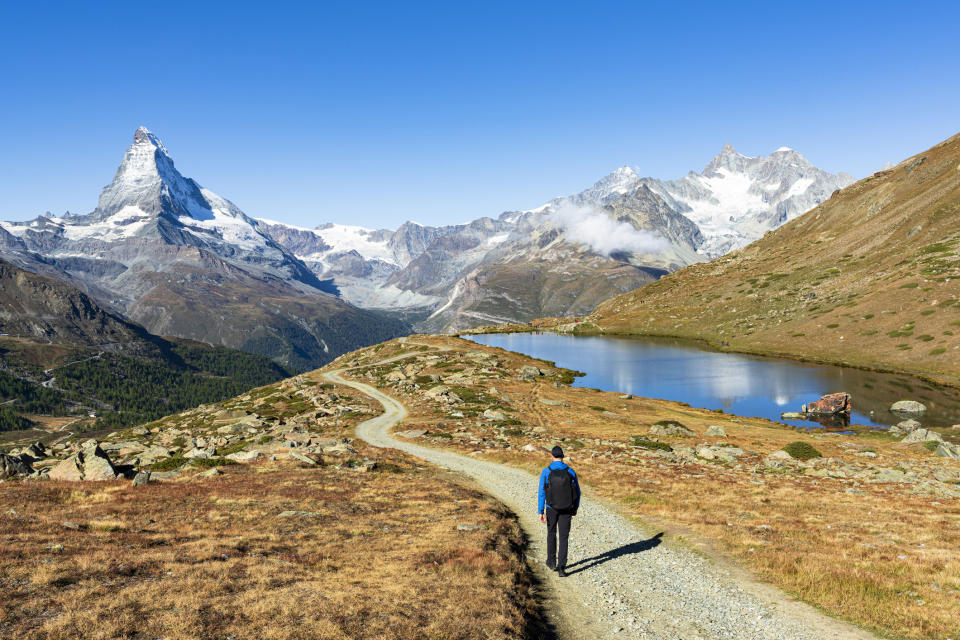 A hiker admiring Matterhorn from path.