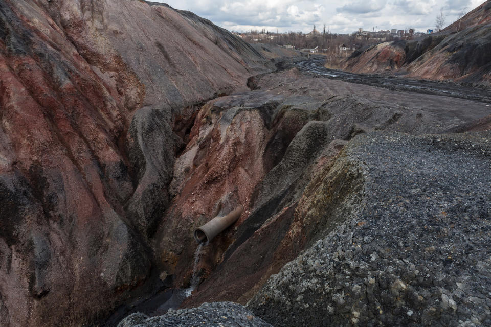 Image: A pipe depositing water from a mine on the slag mountains, which consist of solid waste remaining after coal mining in Toretsk (Oksana Parafeniuk / for NBC News)