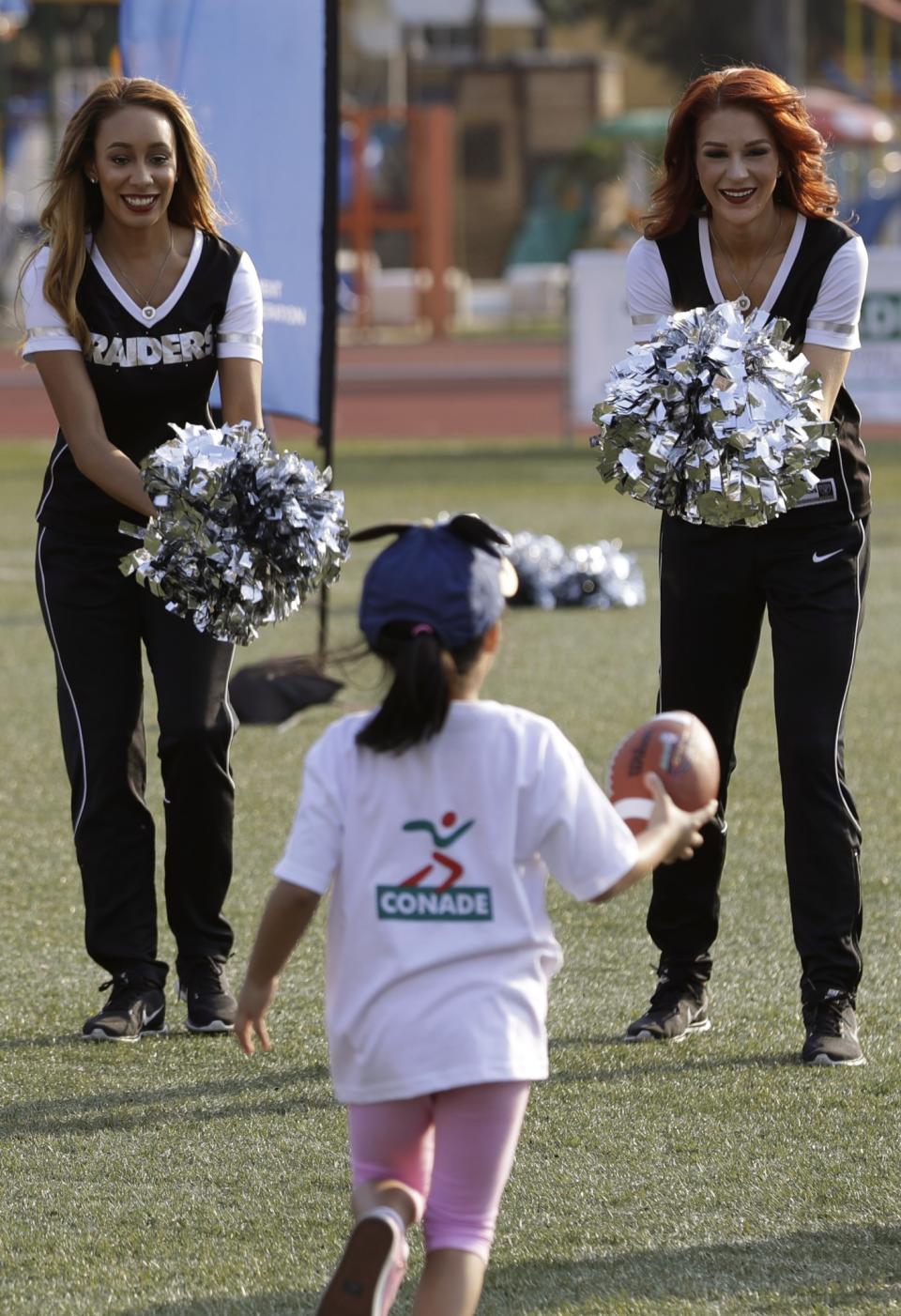 <p>Oakland Raiders cheerleaders Cassie, left, and Wendy, cheer on a little girl during an NFL-sponsored event promoting physical activity in children, in Mexico City, Friday, Nov. 18, 2016. The NFL’s Play 60 campaign encourages children to be active 60 minutes a day to avoid childhood obesity. The Raiders play the Houston Texans on Monday. (AP Photo/Rebecca Blackwell) </p>