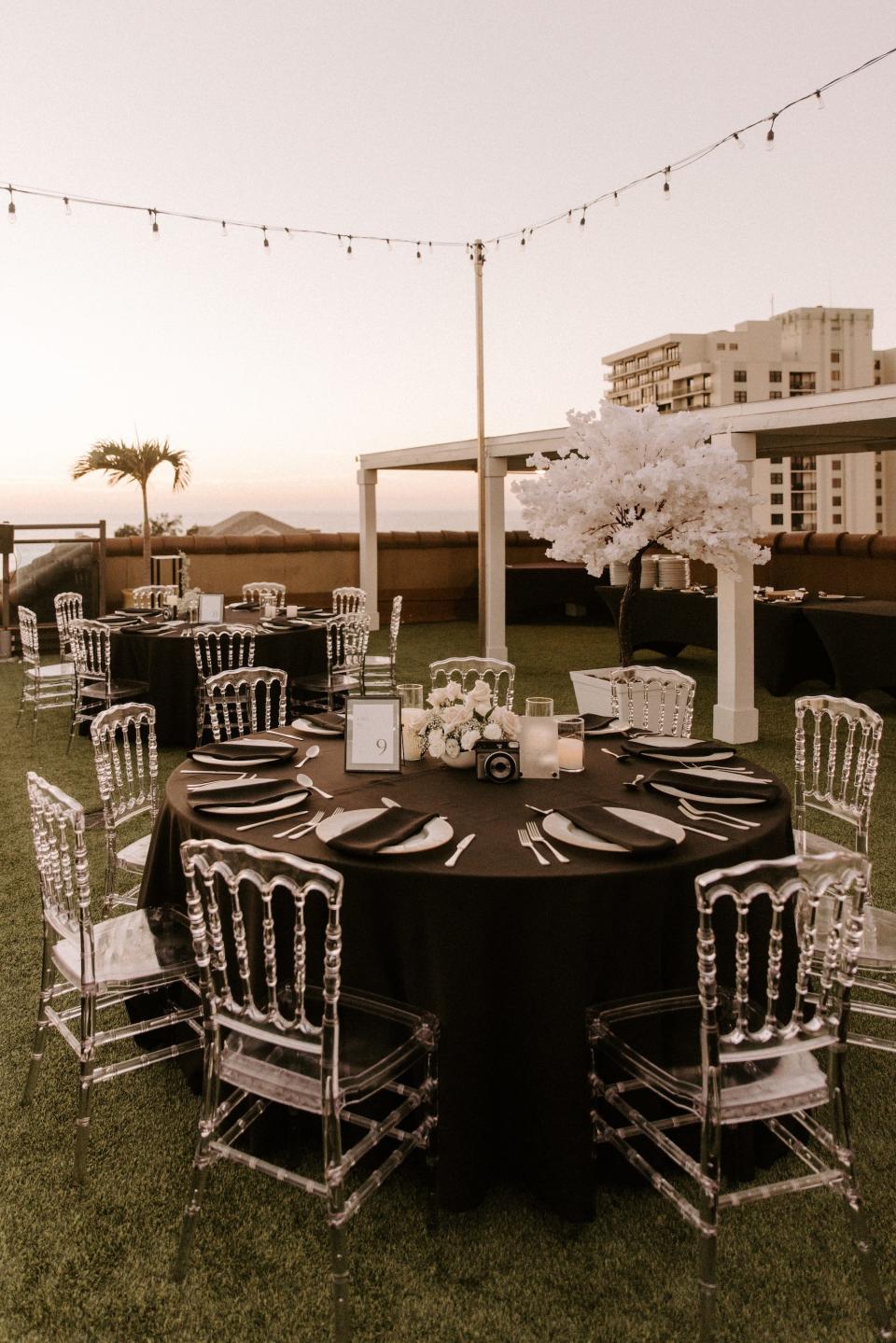 A wedding with black table cloths and white accents.