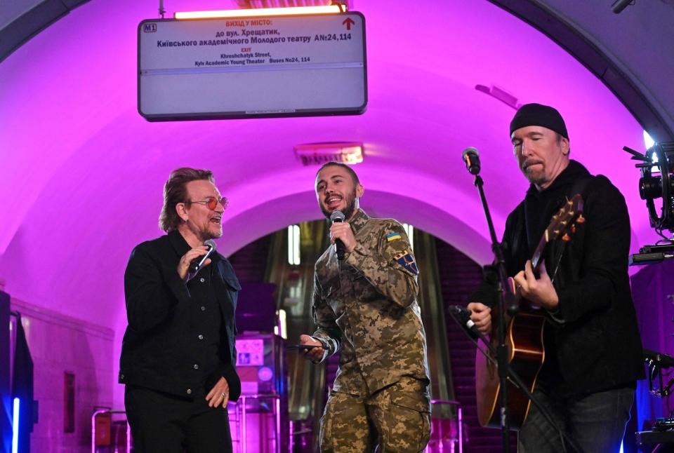 U2 members Bono, left, and The Edge, right, perform with Taras Topolia, lead singer of the Ukrainian rock band  Antytila and army serviceman, during a set at a Kyiv subway station and bomb shelter in May.