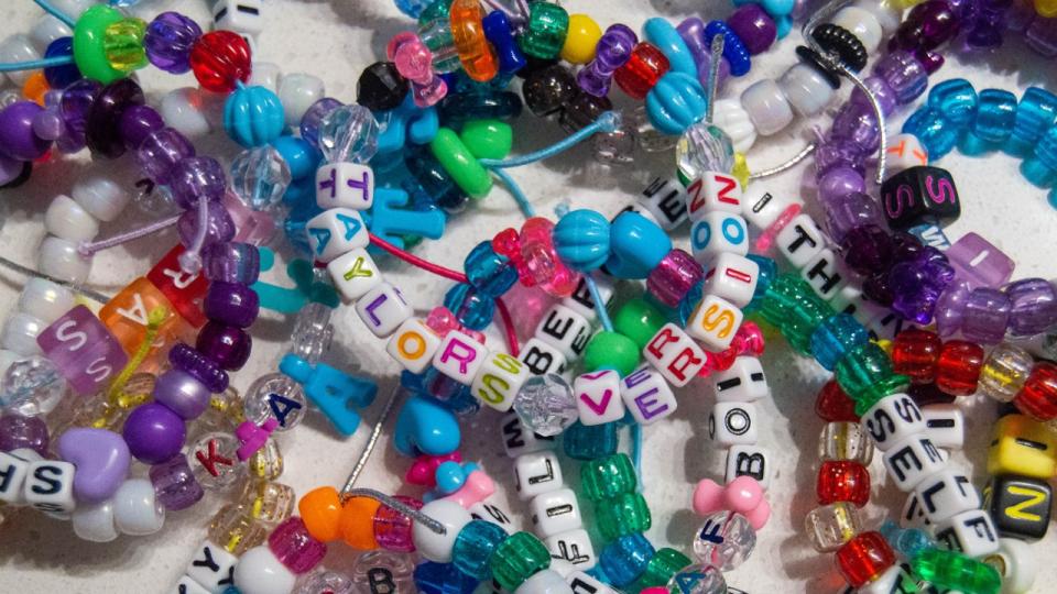 A pile of friendship bracelets, with one that says 