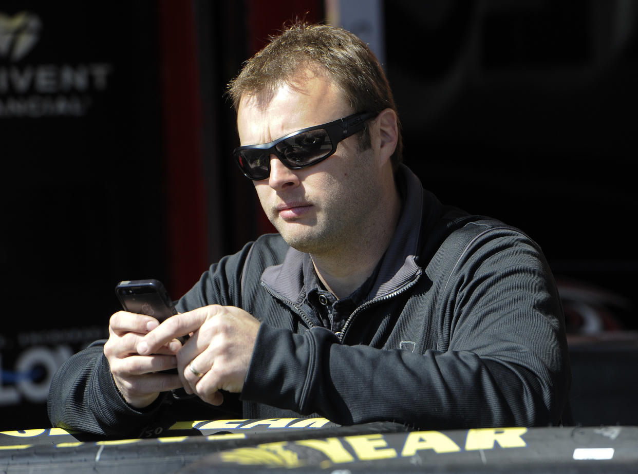 Travis Kvapil, piloto del auto robado en Atlanta, espera en el circuito por la aparición de su máquina. (AP Photo/John Amis)