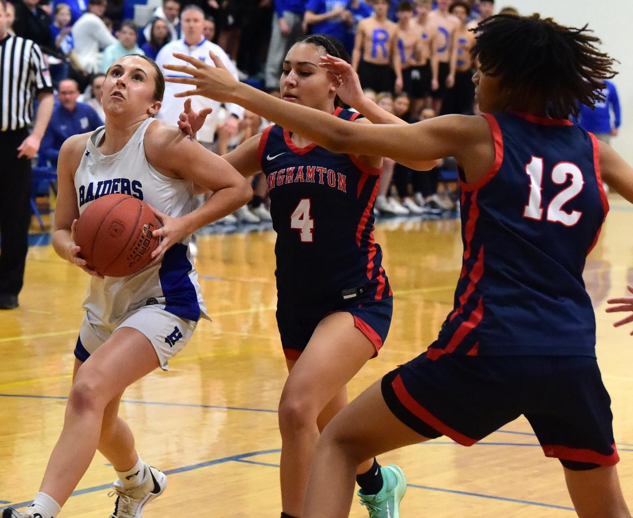 Horseheads' Sophia Bonnell drives to the basket as Binghamton's Shania Beylo (4) and Sa'Niya Glover defend during the Blue Raiders' 52-30 win in a Section 4 Class AA girls basketball semifinal Feb. 27, 2024 at Horseheads Middle School.