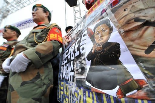 South Korean veterans are seen standing next to a caricature of North Korean leader Kim Jong-Un during an anti-North Korea rally to mark the 2nd anniversary of the sinking of the South Korean naval ship Cheonan, in Seoul, on March 16. N. Korea announced it would launch a long-range rocket next month to put a satellite into orbit, a move that would breach a UN ban imposed after previous launches