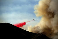 An air tanker drops retardant as the Lake Fire burns in the Angeles National Forest north of Santa Clarita, Calif., on Thursday, Aug. 13, 2020. (AP Photo/Noah Berger)