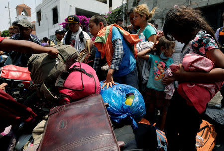 Central American migrants pick up their luggage after arriving in a caravan, as they move through Mexico toward the U.S., in Puebla, Mexico April 6, 2018. REUTERS/Henry Romero