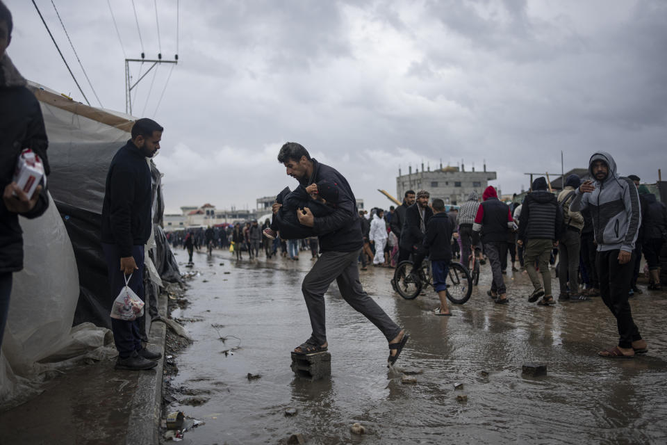 Palestinians displaced by the Israeli air and ground offensive on the Gaza Strip walk through a makeshift tent camp in Rafah on Saturday, Jan. 27, 2024. (AP Photo/Fatima Shbair)