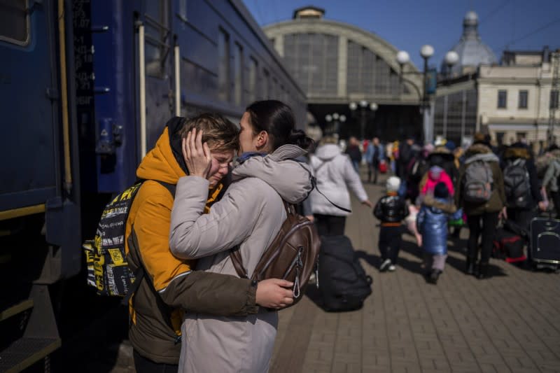2022年3月20日，一位烏克蘭媽媽在利沃夫火車站親吻她逃出圍城馬里烏波爾的寶貝兒子。（美聯社）