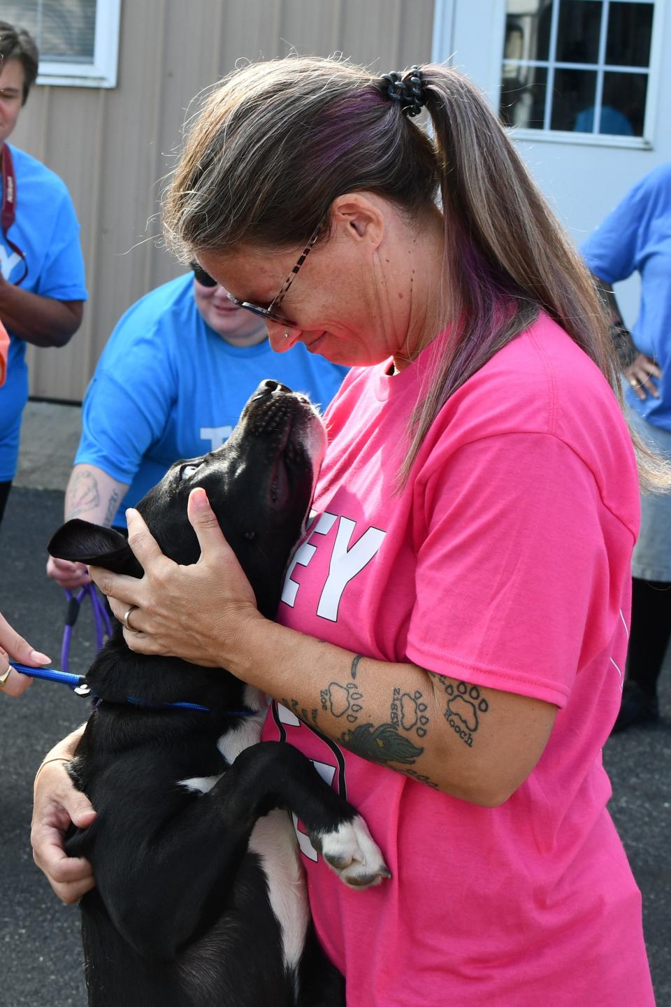 A dog transported from Georgia clings to Karli Crenshaw, founder of Grass Roots Rescue, at the Little Creek Fire Company on September 14, 2024.