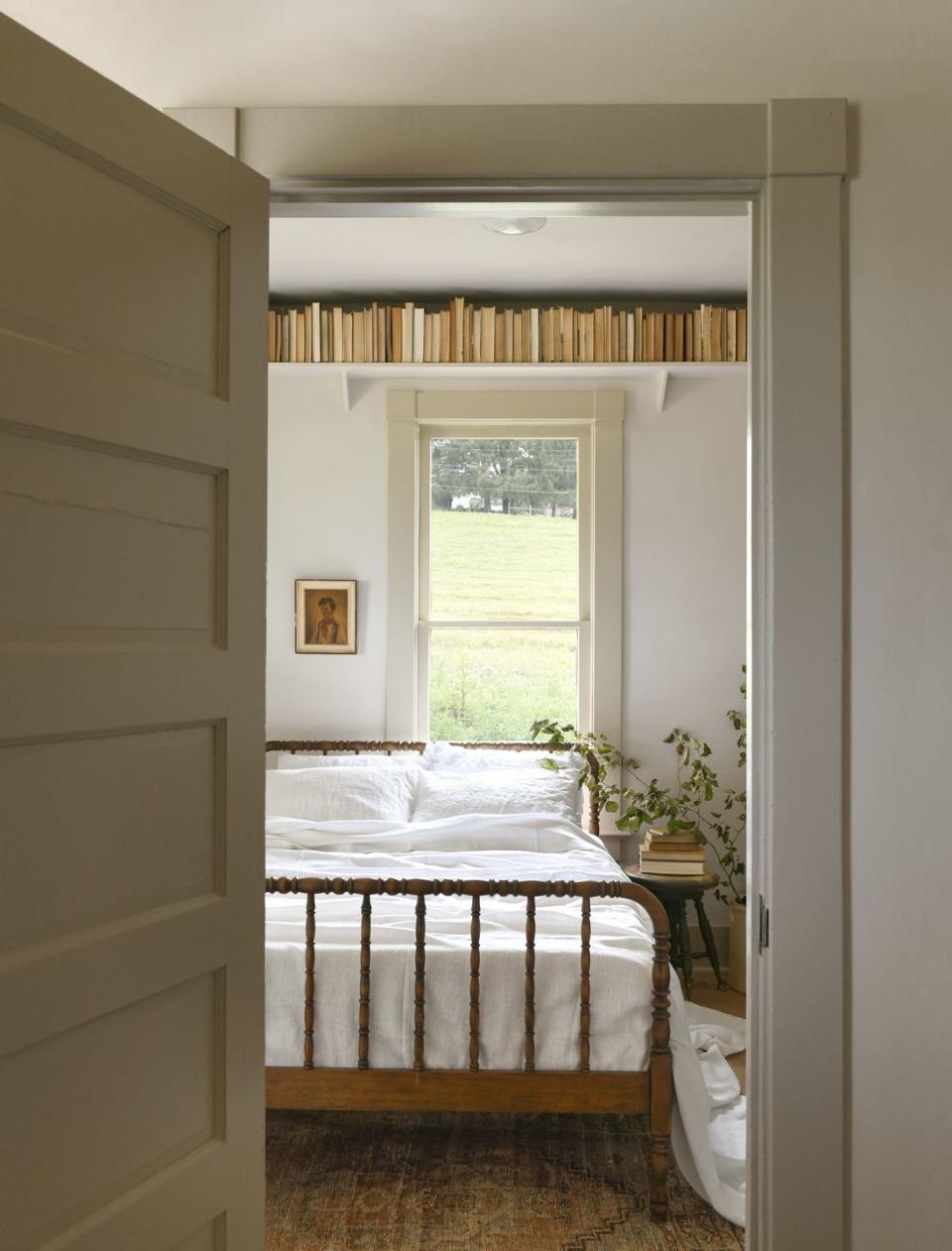 farmhouse bedroom with book shelf above spool bed