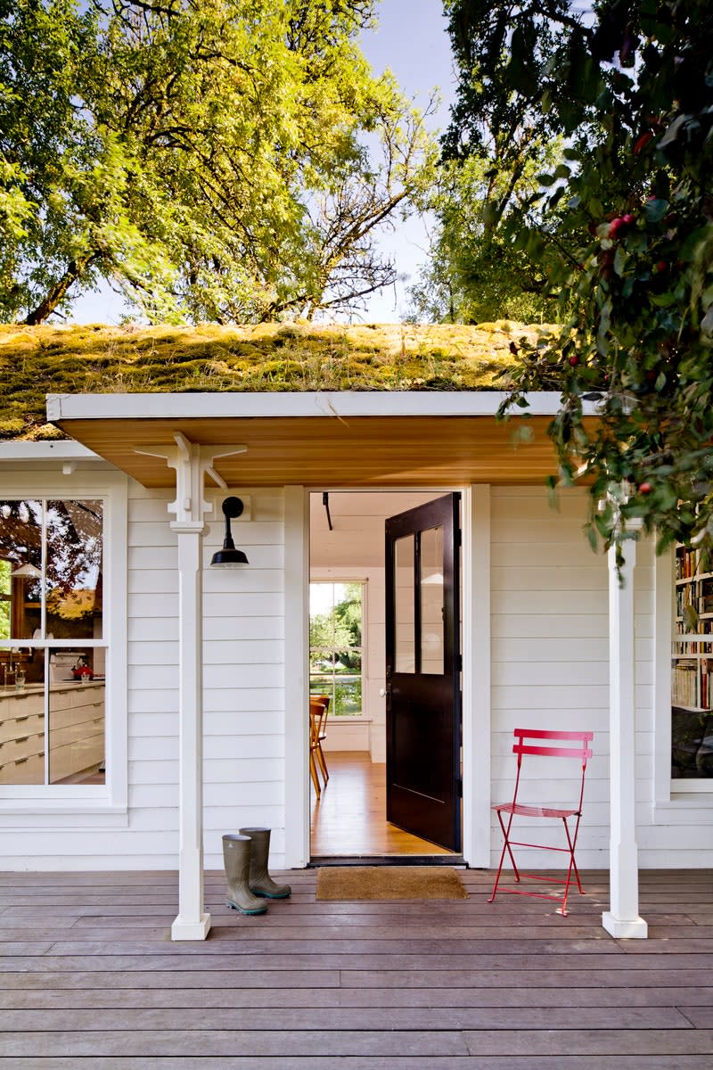 The front porch of the structure welcomes guests thanks in part to its fern-covered green roof.