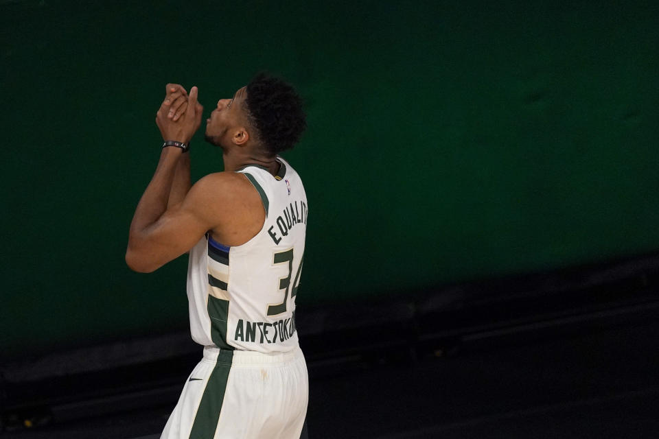 Giannis Antetokounmpo gestures upward with his hands clasped prior to a game.
