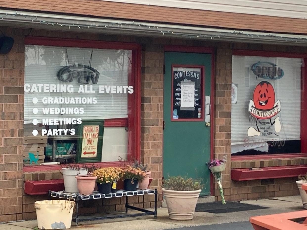 A bouquet of flowers was left outside of Contessa's Pizzeria in North Canton on Thursday following the sudden death of the shop's founder, Geno Ivey.