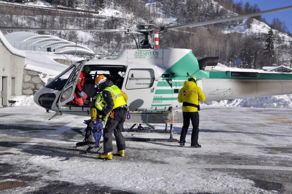 Rescuers prepare to board an helicopter in Aosta, Italy, Monday, Feb. 4, 2019, to reach the spot where the bodies of three skiers where found. Rescuers have found the bodies of three skiers in Italy's Alps and are searching for a fourth, raising the death toll in recent avalanches in the country to at least five. The Valdostano Alpine Rescue aircraft on Monday, searching for two British and two French skiers who were reported missing a day earlier, spotted three bodies. Dogs were helping in the search. (Thierry Pronesti/ANSA Via AP)