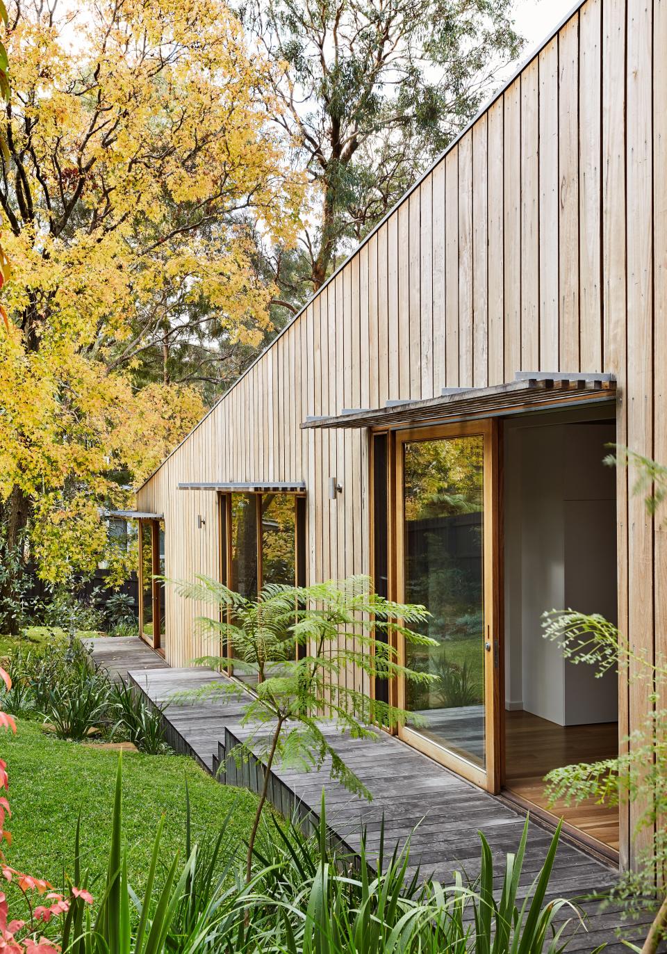 Sliding doors open up the bedrooms to the deck walkway and garden beyond.