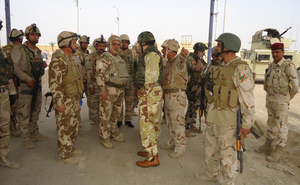 In this photo released by the Iraqi Army taken on March 20, 2014, the commander of Anbar Operations, Lt. Gen. Rasheed Fleih, center, speaks with officers before attacking al-Qaida positions in Ramadi, 70 miles (115 kilometers) west of Baghdad, Iraq. Iraqi military officials are warning that efforts to clear militants from Fallujah and parts of nearby Ramadi are proving much more difficult than they anticipated when the jihadists showed up three months ago. That realization, as they acknowledged during a recent tour of special forces operations, casts doubt on Iraq's ability to hold elections in Fallujah next month. (AP Photo/Iraqi Army)