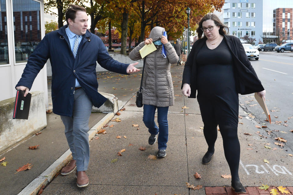 The mother of Patrick Dai, center, leaves the U.S. District Court with her son's attorney in Syracuse, N.Y., Wednesday, Nov. 1, 2023. Dai, a 21-year-old Cornell University student accused of posting threats online to shoot and stab Jewish people on the campus, waived his right to a bail hearing during his first appearance in federal court Wednesday. The judge ordered him to remain in Broome County jail, where he has been since he was arrested. (AP Photo/Adrian Kraus)