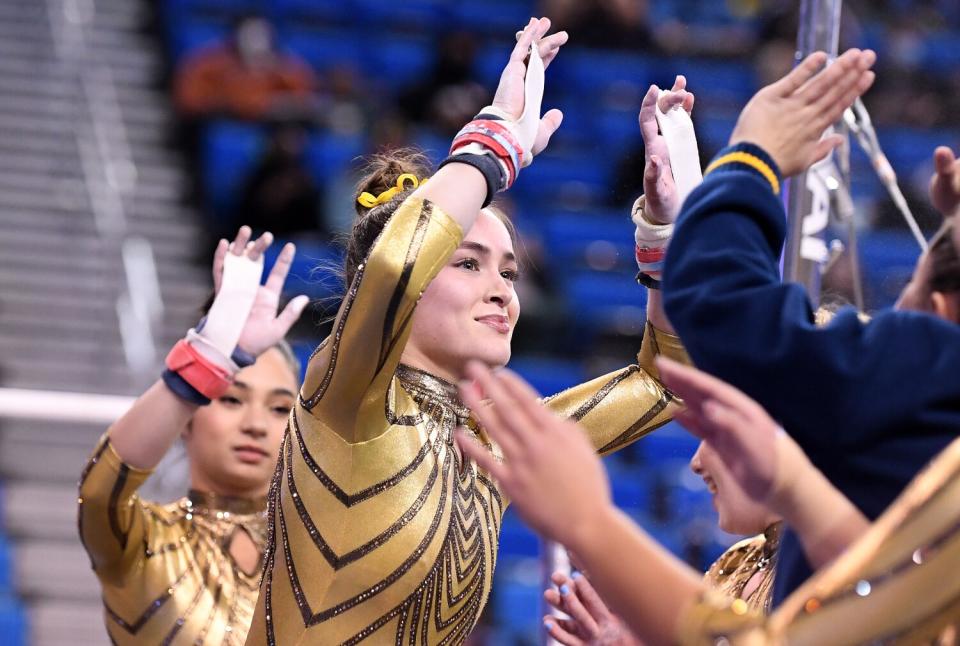 UCLA's Norah Flatley celebrates with teammates after competing on the uneven bars.