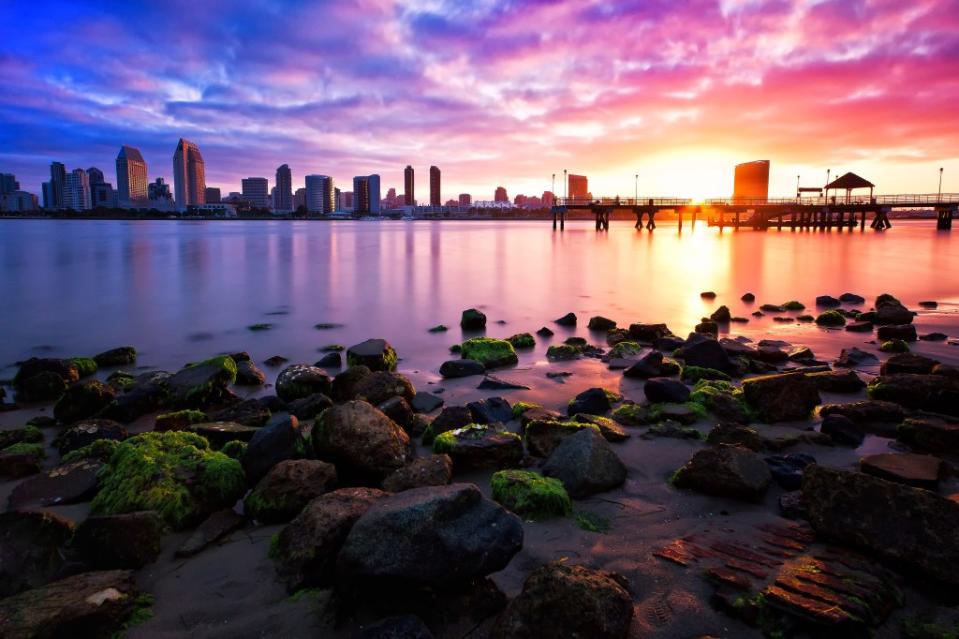 Beautiful colors of Coronado Island shoreline facing the reflective skyline of downtown San Diego via Getty Images