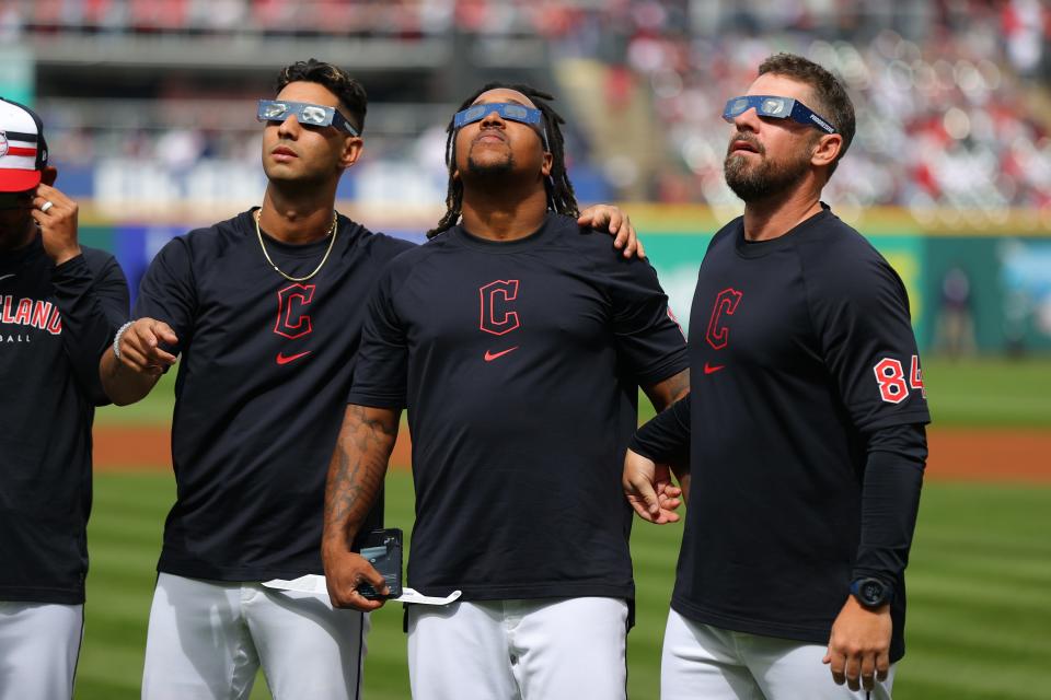 Brayan Rocchio #4, Jose Ramirez #11 and J.T. Maguire #84 of the Cleveland Guardians look up at the total solar eclipse before the home opener against the Chicago White Sox at Progressive Field on April 8, 2024 in Cleveland, Ohio.