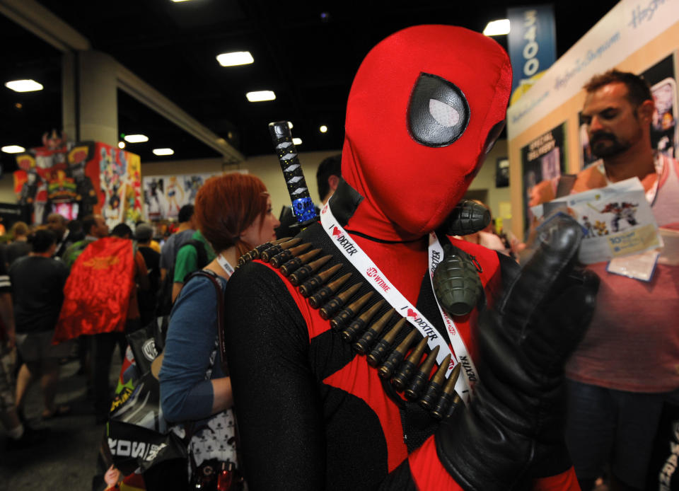 CORRECTS CHARACTER SUBJECT IS DRESSED AS TO DEADPOOL INSTEAD OF SPIDERMAN - Jonah Duhe, dressed as Deadpool, waits in line during the Preview Night event on Day 1 of the 2013 Comic-Con International Convention on Wednesday, July 17, 2013 in San Diego. (Photo by Denis Poroy/Invision/AP)